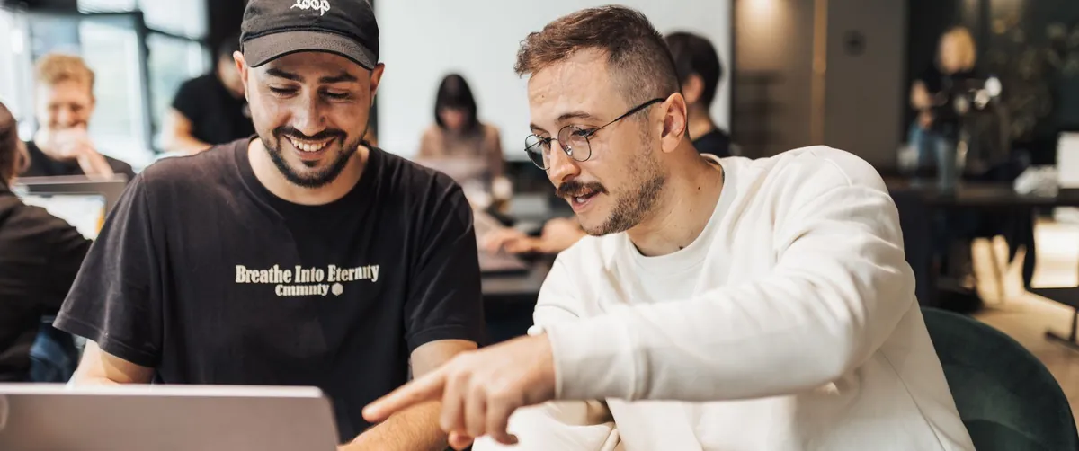 Two people working through a job search together at a laptop